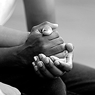 A couple hold hands while they attend sex therapy.