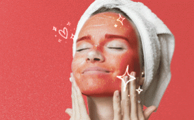 A woman applying a period blood face mask.