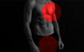 A bright red circle sits over a man's heart while a darker red circle sits over his groin.